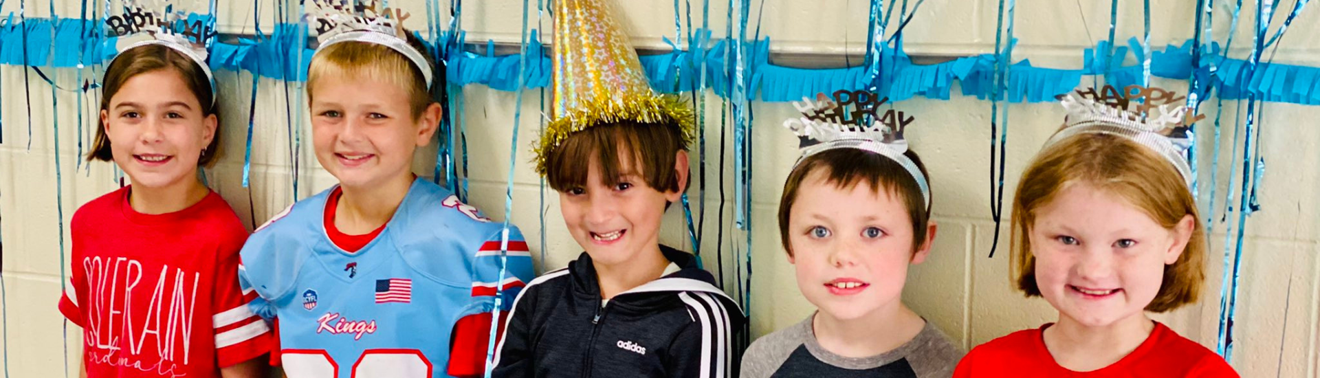Five third grade students posing with birthday hats on